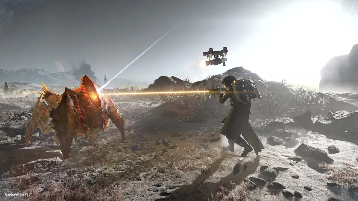 Helldivers 2 co-op firefight with armored troopers facing waves of alien enemies on a hostile planet surface