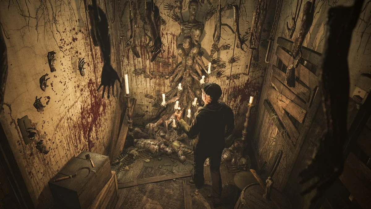 Photorealistic horror game scene showing a hooded figure in a candlelit ritual chamber with bloodstained walls, severed hand props and decaying torso effigy